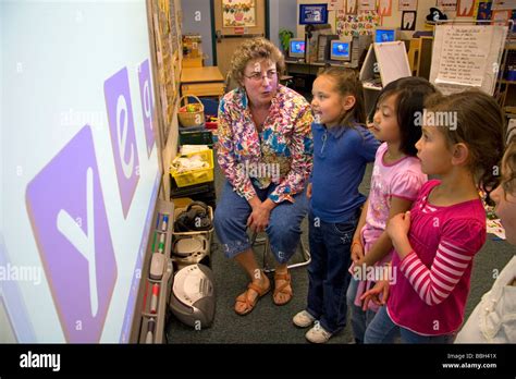 Kindergarten Students Use An Interactive Whiteboard In The Classroom Of