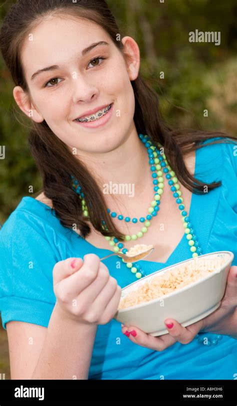 Pretty Caucasian Teen Girl 13 To 15 Smiles And Eats Cereal Outdoors Usa