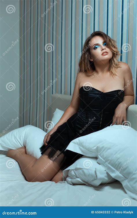 Красивая девушка на кровати среди подушек Стоковое Фото изображение насчитывающей женщина