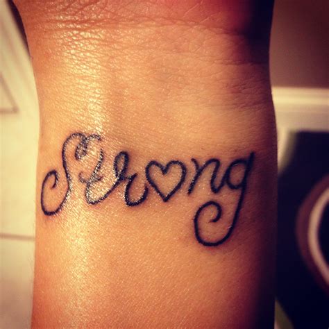 A Small Wrist Tattoo With The Word Love Written In Cursive Writing On It