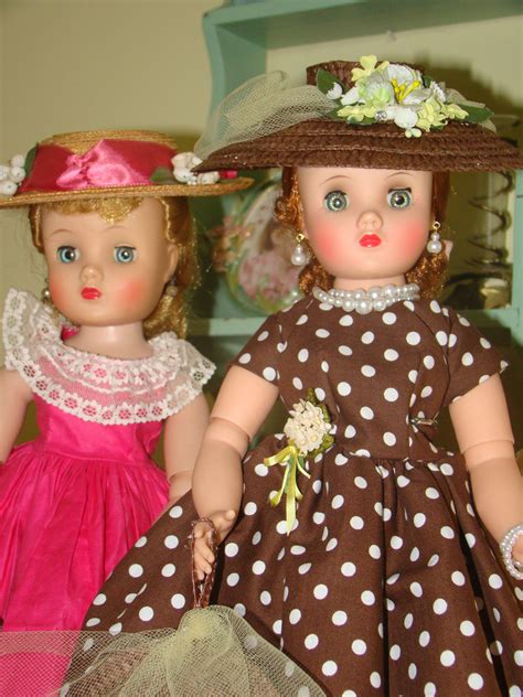 Two Dolls Dressed In Brown And White Polka Dot Outfits One Wearing A