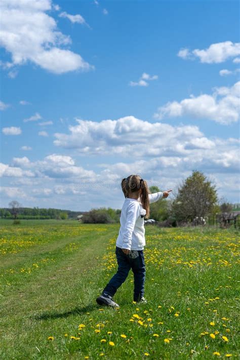 Little Girl Walks In A Beautiful Spring Field And Shows Her Hand