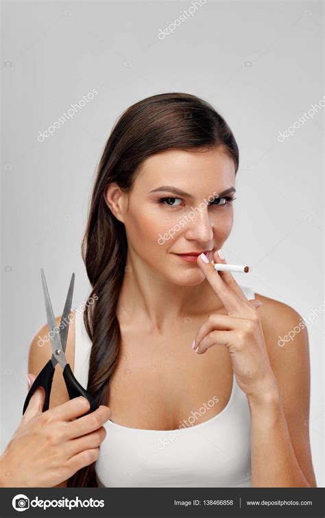 Closeup Of Beautiful Woman With Scissors Smoking Cigarette