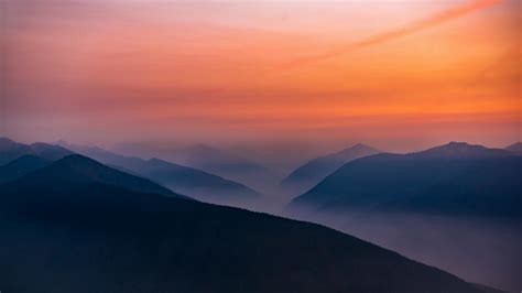 Download Wallpaper 1366x768 Hazy Sunset Mist Mountains Horizon