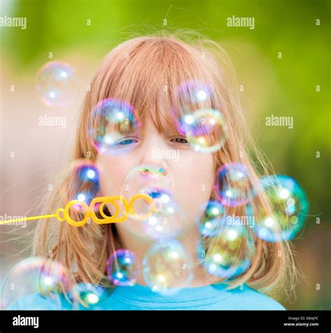 Boy With Long Blond Hair Blowing Soap Bubbles Stock Photo Alamy