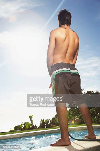 Young Man Refilling The Swimming Pool With A Water Hose Photo Getty