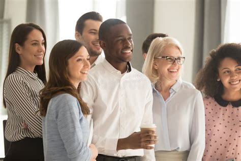 Smiling Diverse Employees Team Posing For Company Photo In Office Stock