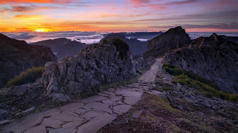 Stone Path Between Green Grass Field And Rock Mountains During Sunset