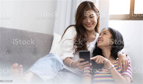 Young Beautiful Asian Women Lesbian Couple Lover Using Smartphone Video Call Online In Living