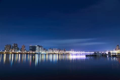 2560x1440 Wallpaper City Buildings With Lights Near Body Of Water