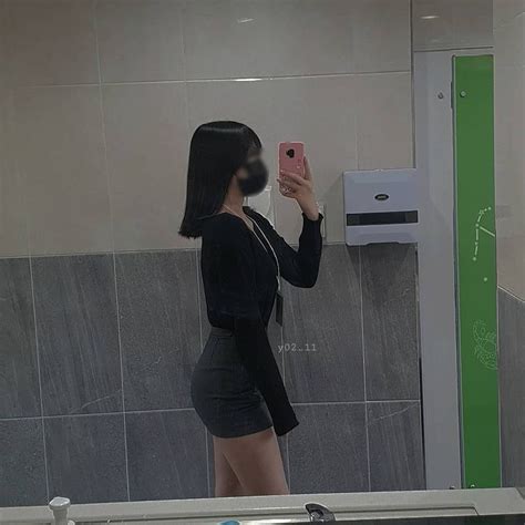 A Woman Taking A Selfie In Front Of A Bathroom Mirror With Her Cell Phone