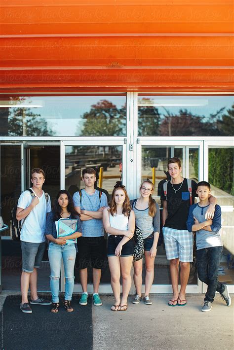 Group Of Serious High School Teens Standing In Front Of School On Summer Day Del Colaborador