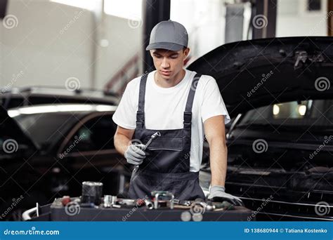 A Young Automechanic Is Focused On The Process Of Repairing A Car Stock