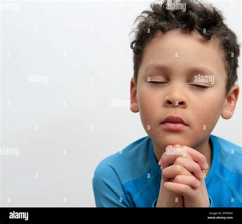 Niño Orando A Dios Con Las Manos Sostenidas Junto Con Cerrado Ojos En