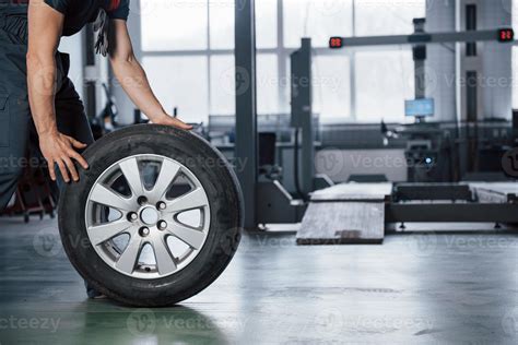 Grounded view. Mechanic holding a tire at the repair garage