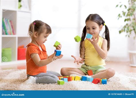 Cute Children Playing While Sitting On Carpet At Home Stock Image