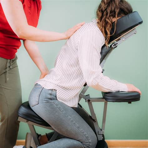 corporate stress relief chair massage in the office corporate female employee sitting on