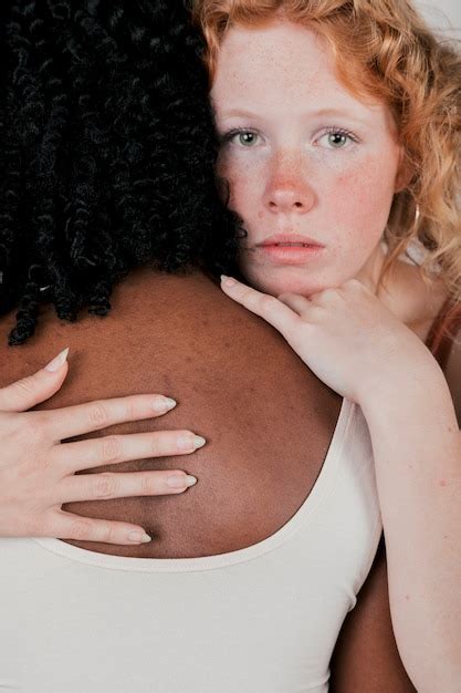 アフリカの女性を抱いて白人の若い女性の肖像画 無料の写真
