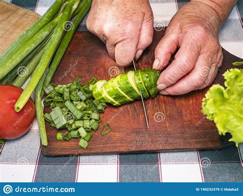 Cutting A Vegetable A Green Cucumber With A Knife On A Cutting Board