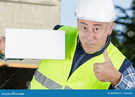 Handsome Worker Shows Thumbs Up While Holding Blank Board Stock Photo