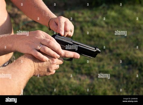 The Man Holds A Gun In His Hands And Shows His Work Learning To Use A