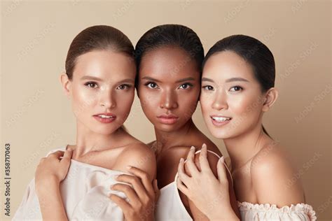 beauty portrait of diversity models mixed race asian and caucasian girls hugs each other and