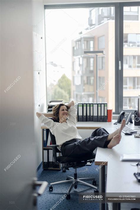 Businesswoman Relaxing In Office With Feet On Desk — Female Table
