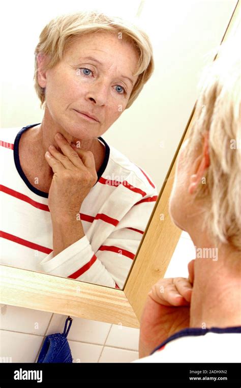 Model Released Ageing Sixty Year Old Woman Examining Her Face In The