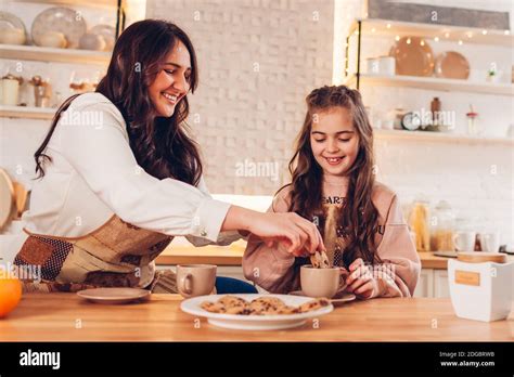 Familia Bebiendo Té Con Galletas En Casa Madre E Hija Riendo Bebiendo