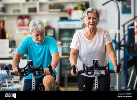 Couple Of Mature People Or Active Seniors Doing Exercise In The Gym