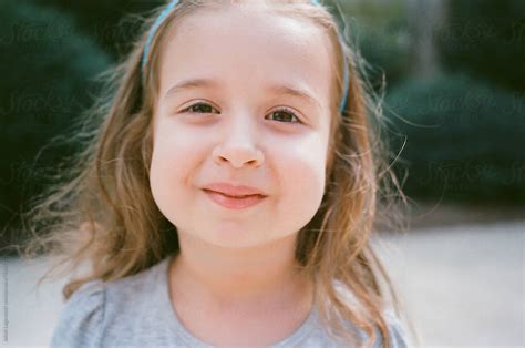 Close Up Portrait Of A Cute Young Girl With Big Cheeks By Stocksy