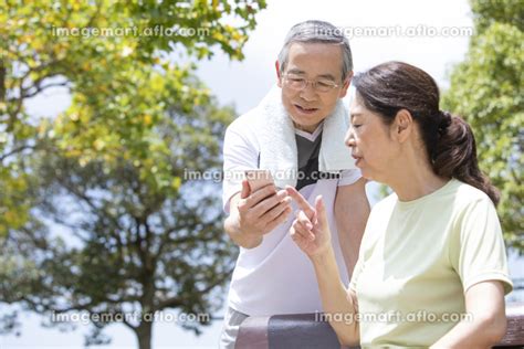 スマートフォンを見るシニアカップルの写真素材 104006151 イメージマート