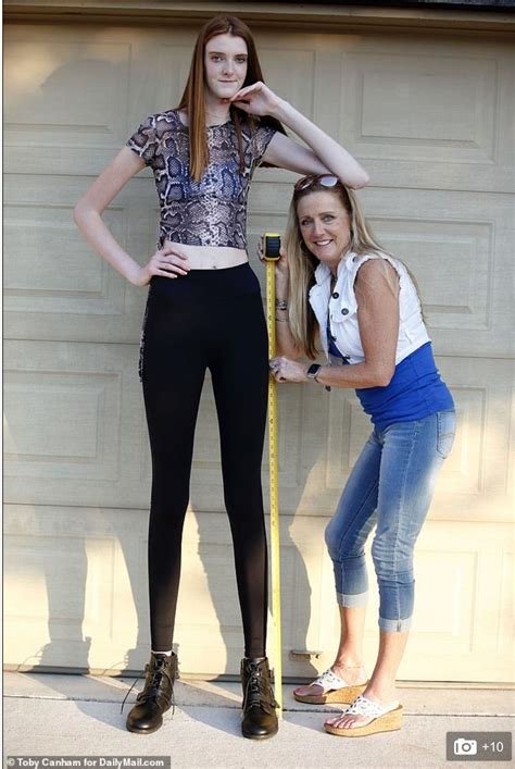 Two Women Standing Next To Each Other In Front Of A Garage Door With A Measuring Tape