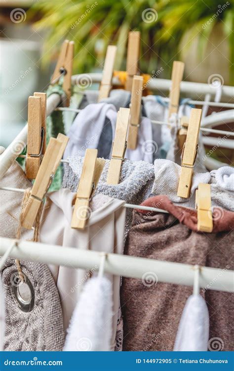 White And Colored Linen To Be Dried On The Clothesline With Wooden