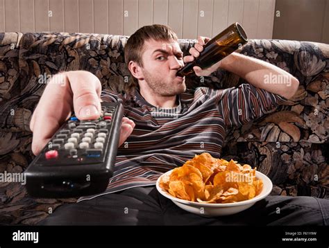 Man With Beer And Chips Watching TV At Home Stock Photo Alamy