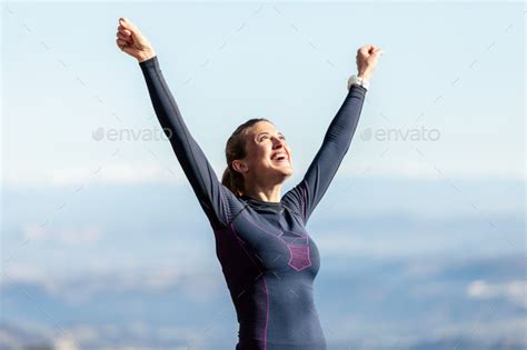Trail Runner With Open Arms Raised While Enjoying Nature On Moun Stock