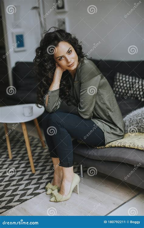 Beautiful Young Woman Sitting By The Table In The Room Stock Image