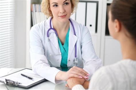 Premium Photo Happy Blonde Female Doctor Looking At Patient While