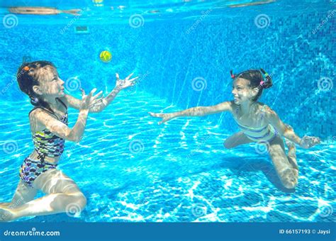 Дети плавают в бассейне подводном счастливые активные девушки имеют