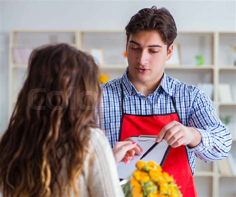 the flower shop assistant selling flowers to female customer stock image colourbox