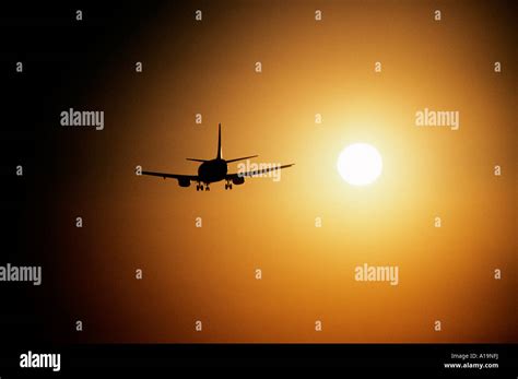 A Commercial Airliner Flies Into The Sunset Stock Photo Alamy