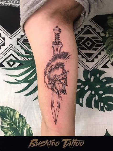 Tatuagem Ornamental De Capacete Espartano Com Espada No Braço