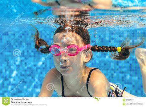 Child Swims In Pool Underwater Happy Active Girl In Goggles Has Fun In