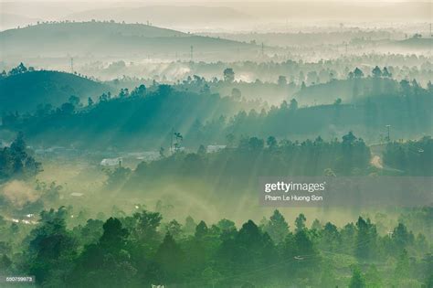 Fog Rolling Over The Hill At Sunrise With Sunbeam High Res Stock Photo