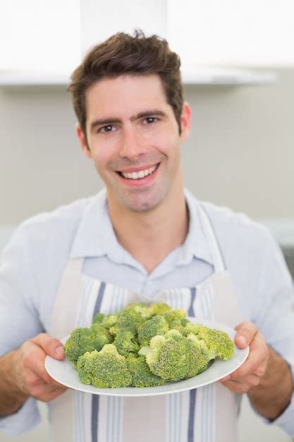 Premium Photo Smiling Man Holding A Plate Of Broccoli In Kitchen