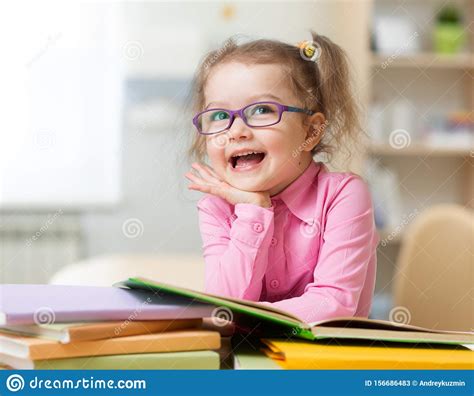 Smart Kid Girl In Eye Glasses Reading Books In Her Room Stock Image
