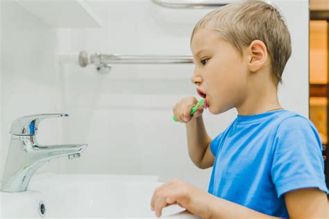 A Child Brushes His Teeth With A Toothbrush In The Bathroom Prevention