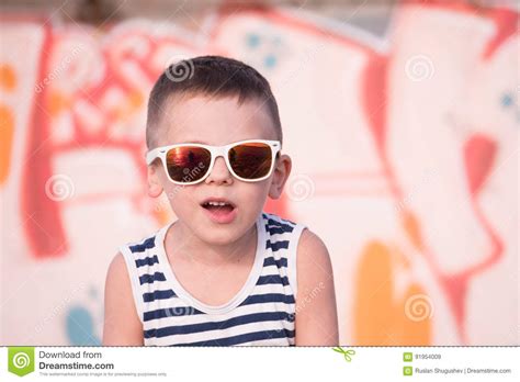 Funny Small Kid Wearing Sunglasses And Shirt On Graffiti Background