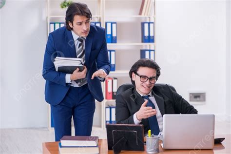 The Boss And His Male Assistant Working In The Office Boss And His Male Assistant Working In The