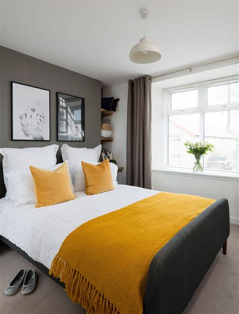 If you're interested in using patterned wallpaper on an accent wall in your bedroom, stick with solid colors throughout the rest of the decor to avoid it becoming too busy. A master bedroom in a grey colour scheme with double bed ...